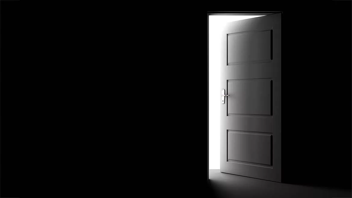 A partly open door with bright light beyond it